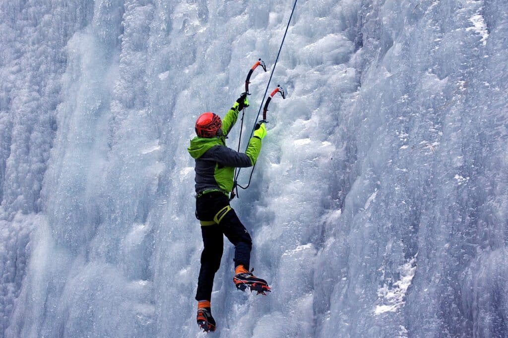 close up of a woman, ice climbing bouldering on a icy rock formation
