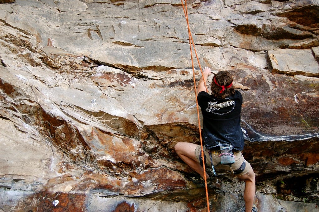 man demonstrating the safety of one of his popular trad climbing harnesses