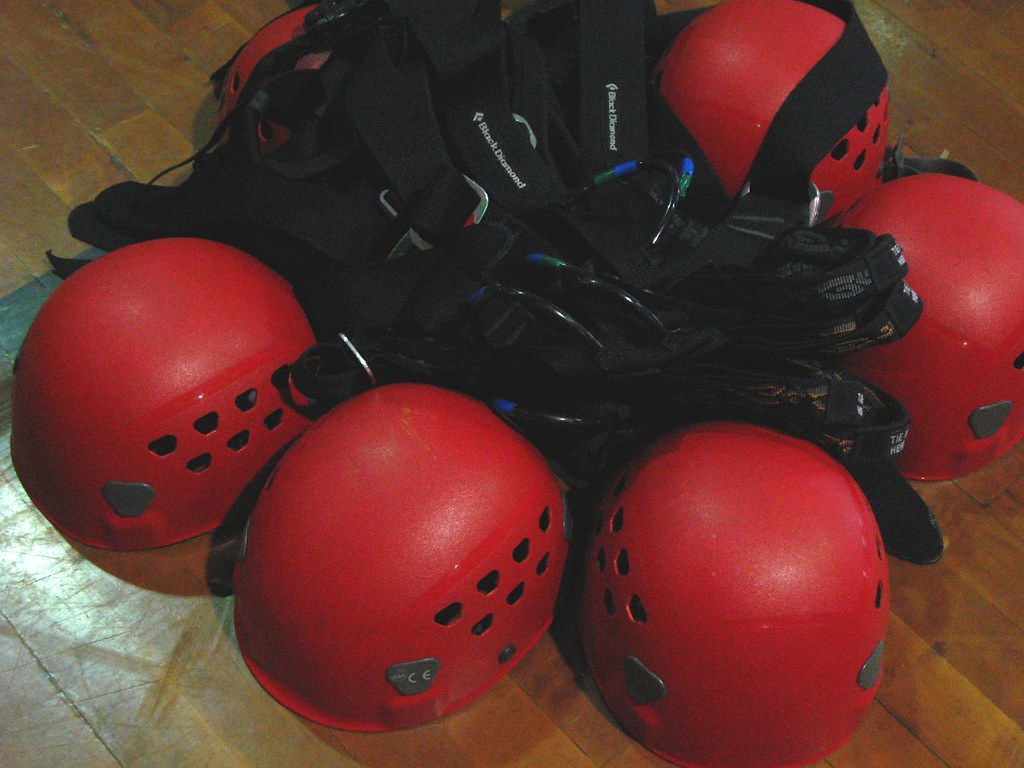 close up photo of rock climbing helmets and harnesses highlighting the importance of safety in trad climbing top rope
