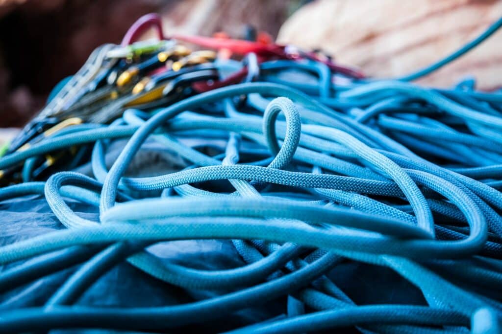 closeup photo of blue ropes and rock climbing slings, covered in the rock climbing etiquette article.