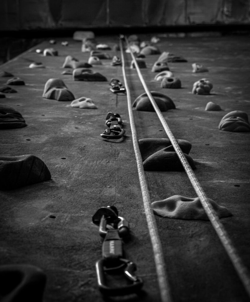 a black and white photo of a indoor rock climbing wall