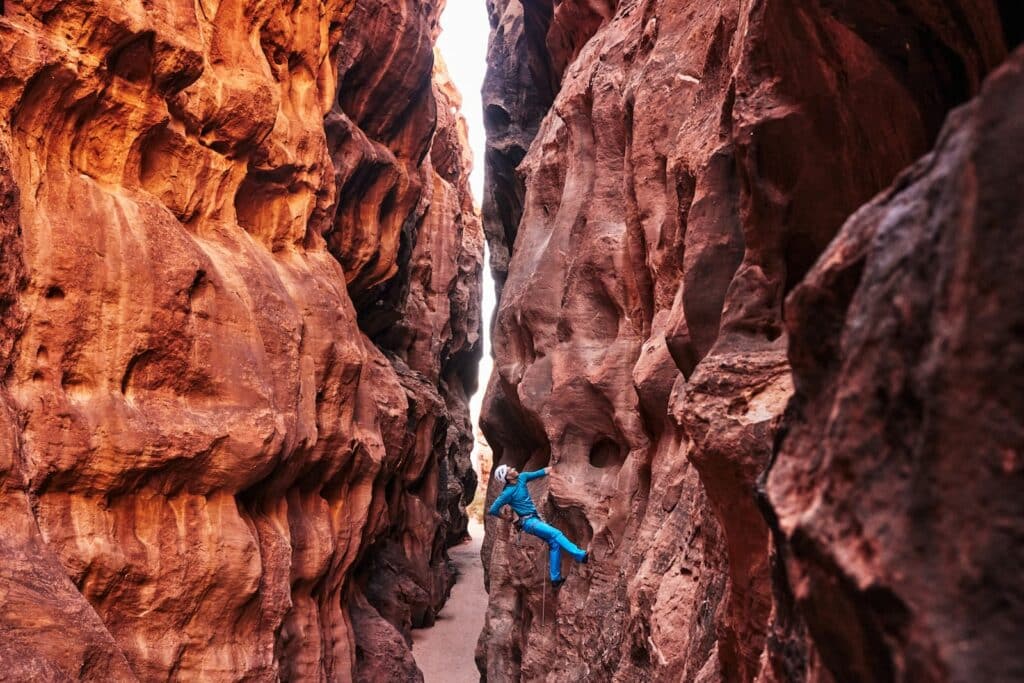 Man ascending sheer cliff, epitomizing spirit of best rock climbing documentaries