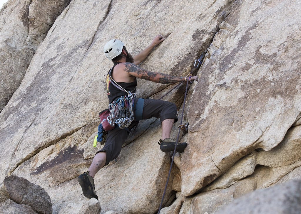 close up of man climbing rock face of a trad climbing routes