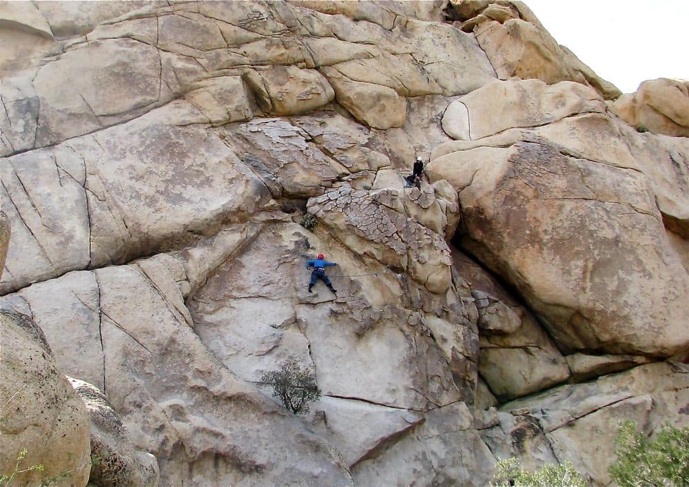 photo of two men climbing a rock formation in Joshua Tree National Park, covered in the Joshua Tree Climbing Guide