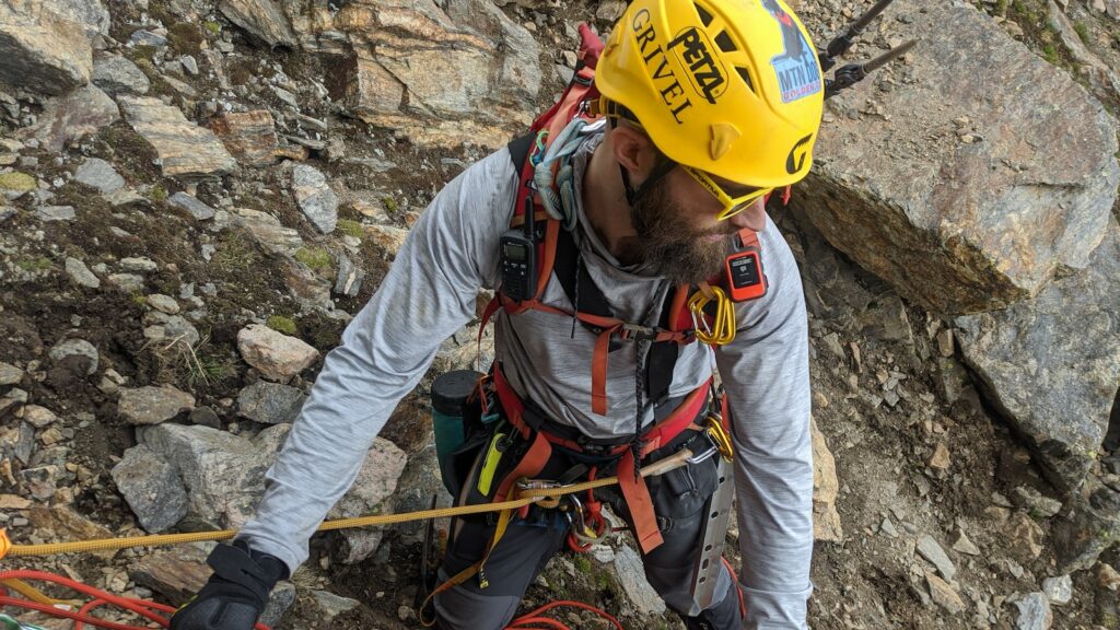 man scaling a rock formation displaying various safety gear as covered in the best rock climbing destinations article