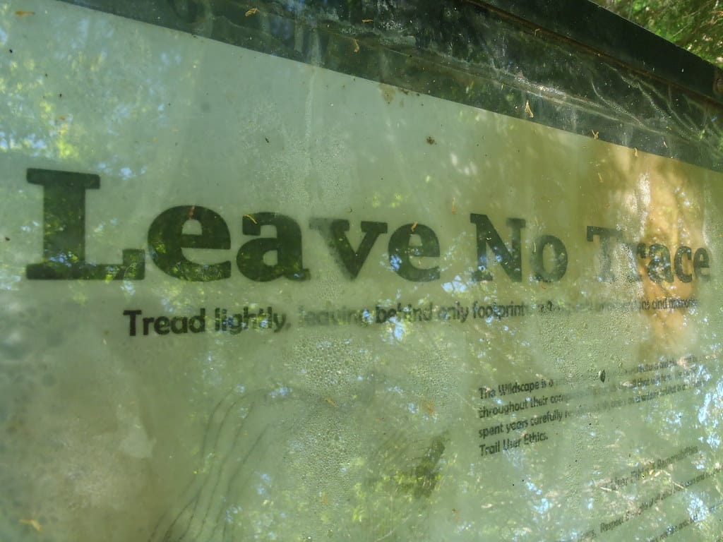 a close up photo of a sign reading 'Leave No Trace', a concept covered in the rock climbing etiquette article.