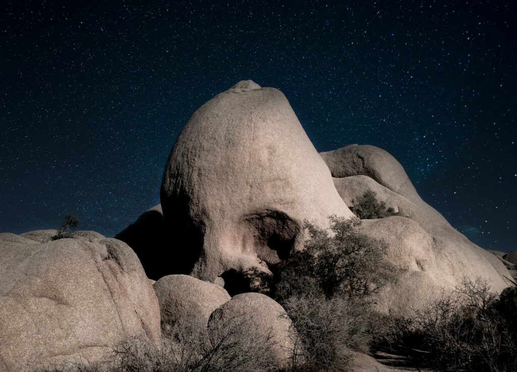 a night time photo of notorious joshua tree rock formations named 'Skull Rock'.