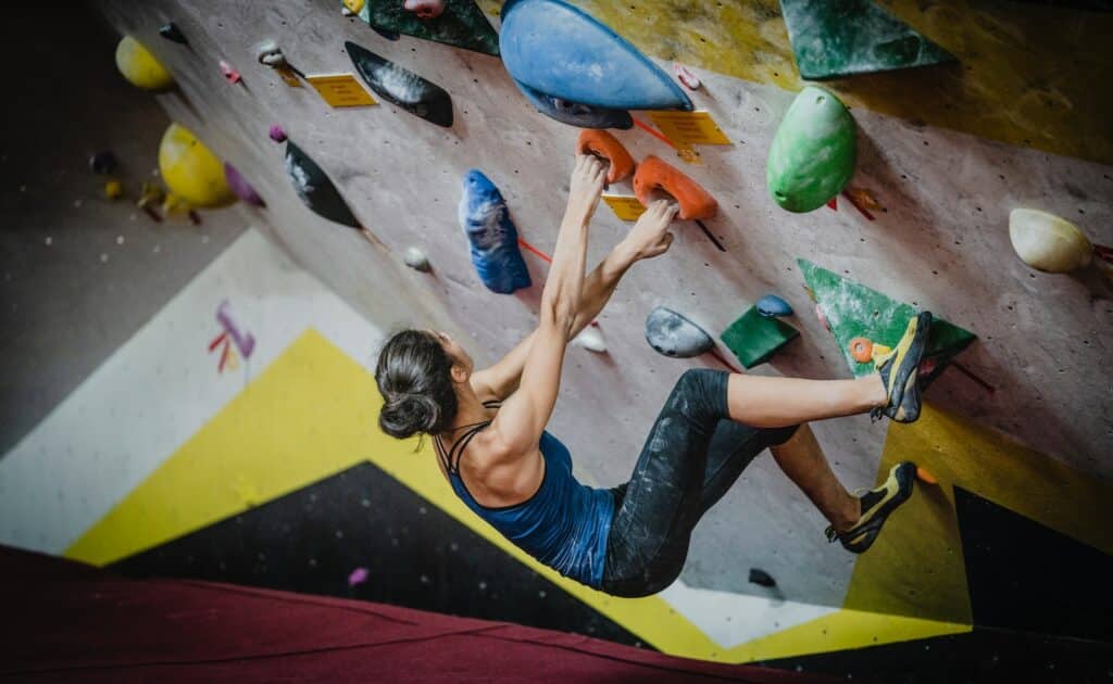 woman trad climbing inside building