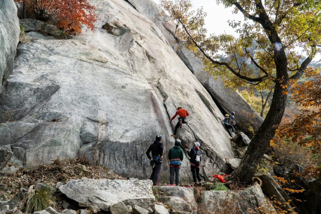group of climbers at the base of a rock wall demonstrating trad climbing offwidth
