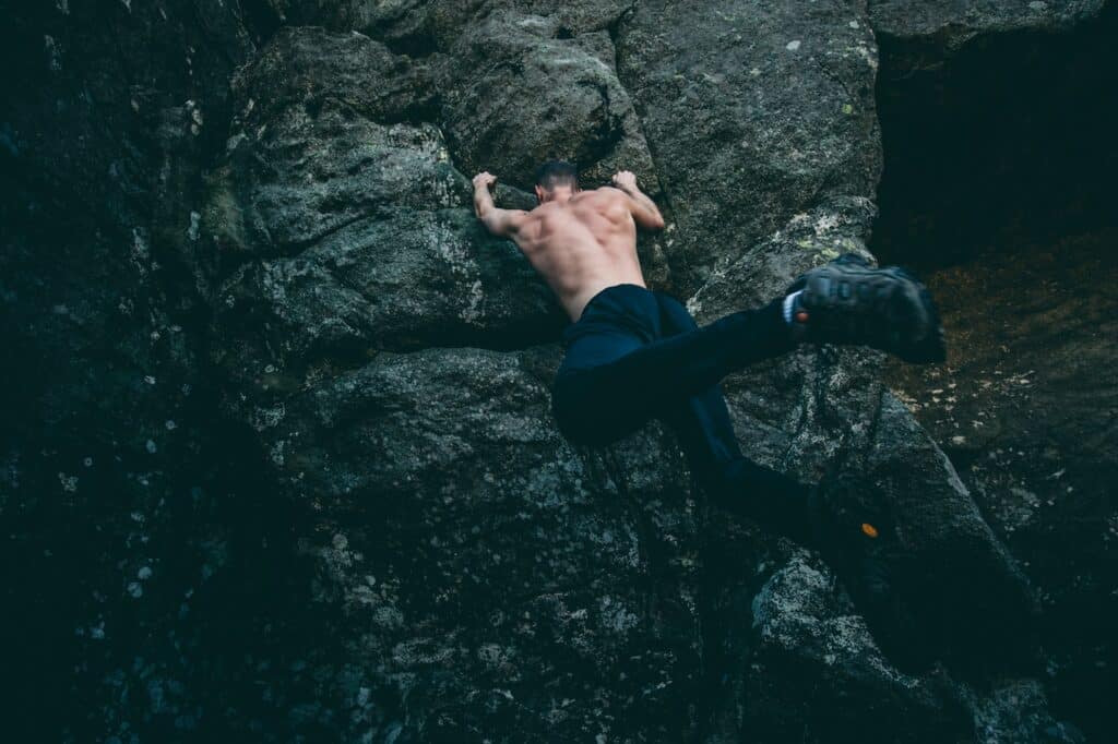 Adventurous climber ascending a steep rock formation, echoing the thrilling action found in movies from the 'Rock Climbing Films Every Adventurer Should Watch' article.