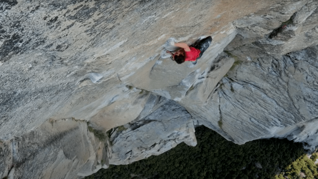 daytime photo of one of the most notable rock climbers of all time Alex Honnold on a free solo rock climbing route as covered in the History of Rock Climbing article