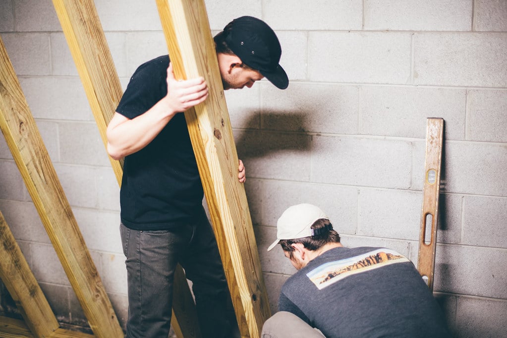 two men installing the foundation of a DIY rock climbing wall