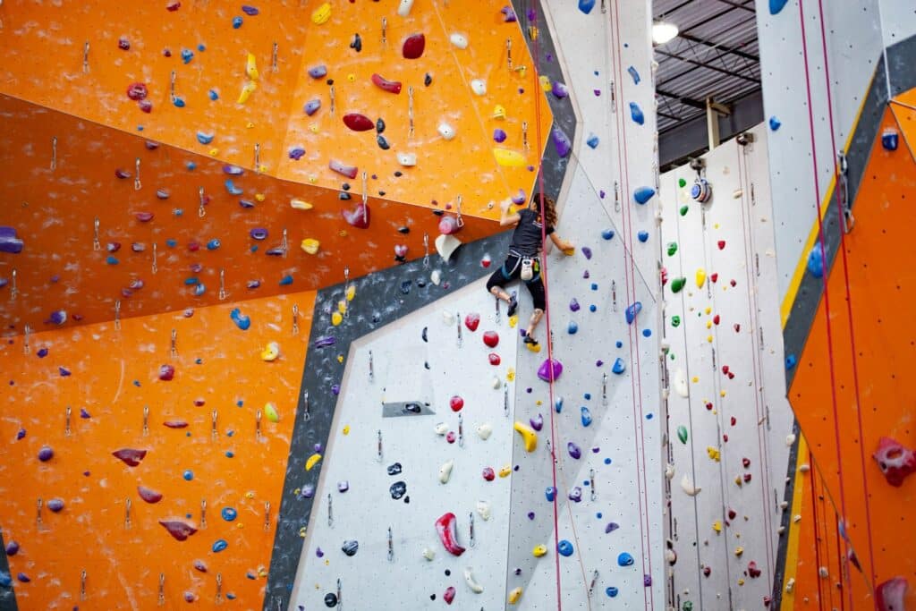 a woman climbing an indoor diy rock climbing wall